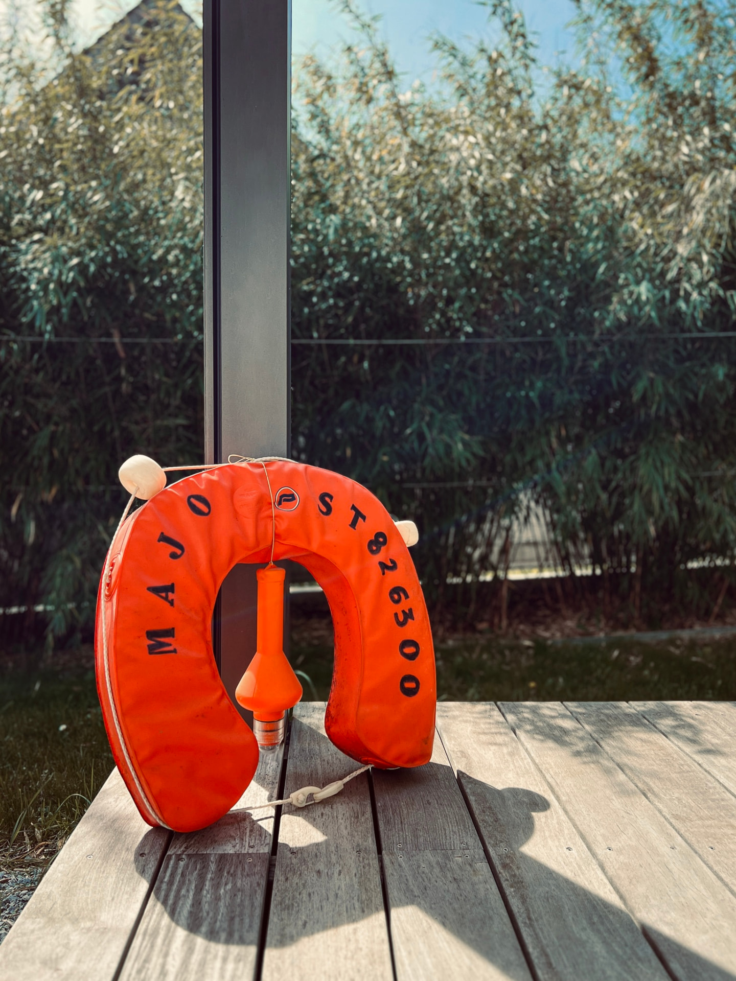 Bouée du bateau Majo posée sur une terrasse en bois, clin d'œil à l'histoire de l'agence