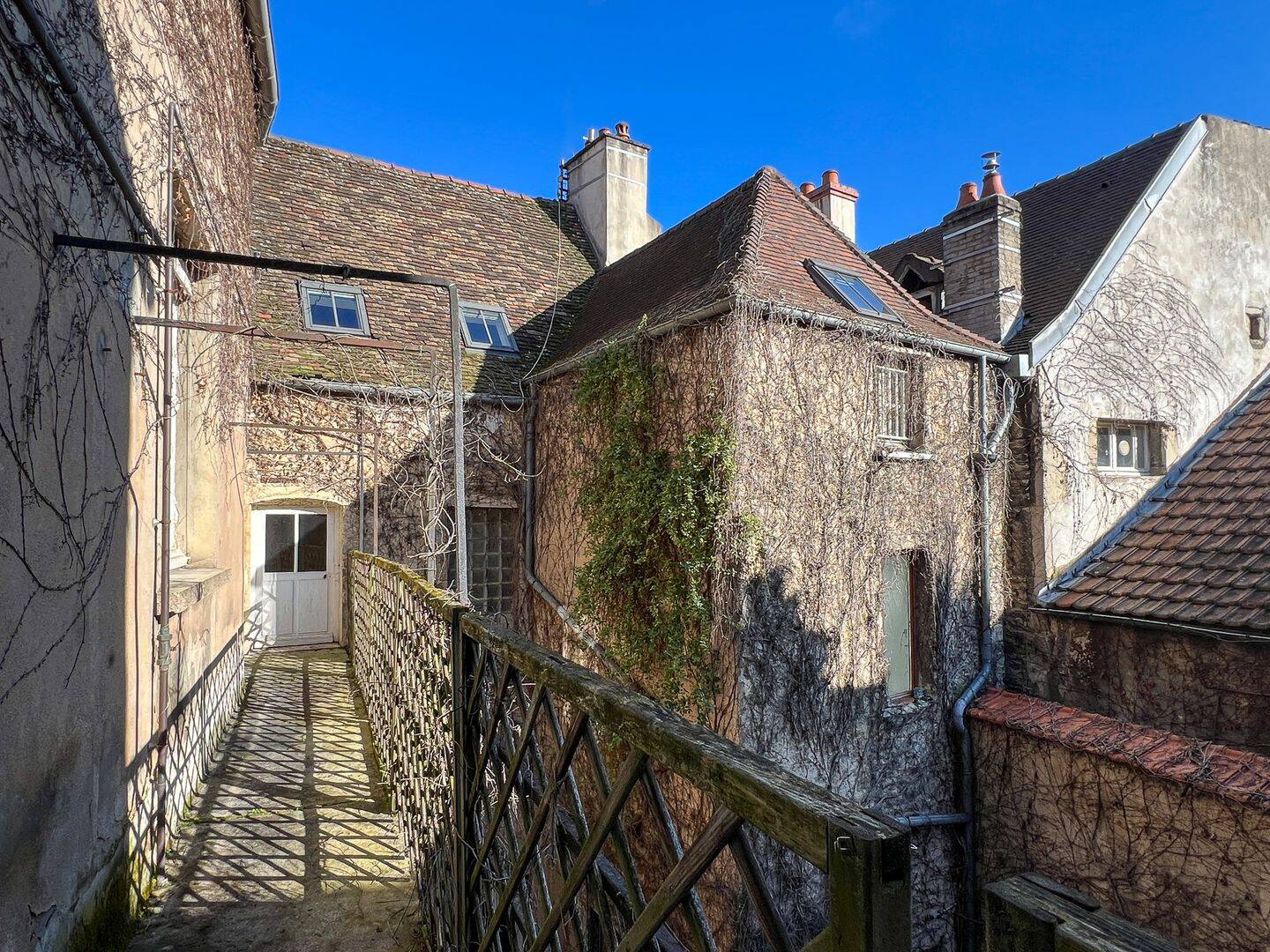 Coursive et façades anciennes en fond de cour