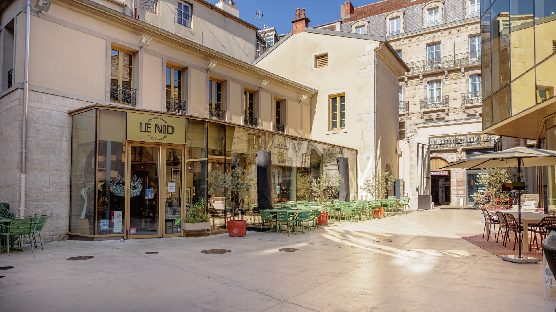 Cour Bareuzai baignée de soleil : façades, terrasses et porche d'entrée