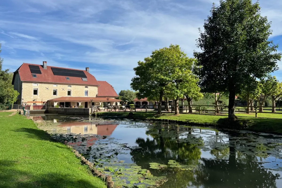 Ancien moulin en pierre reflété dans un étang