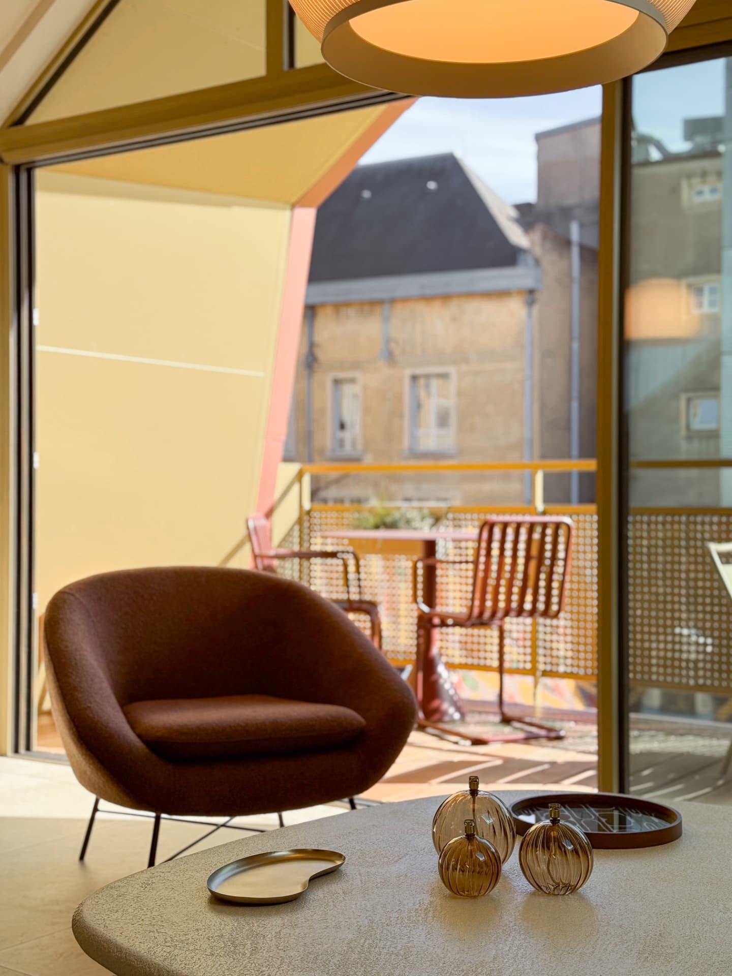 Fauteuil de l'agence MAJO devant la baie et la terrasse, matières naturelles