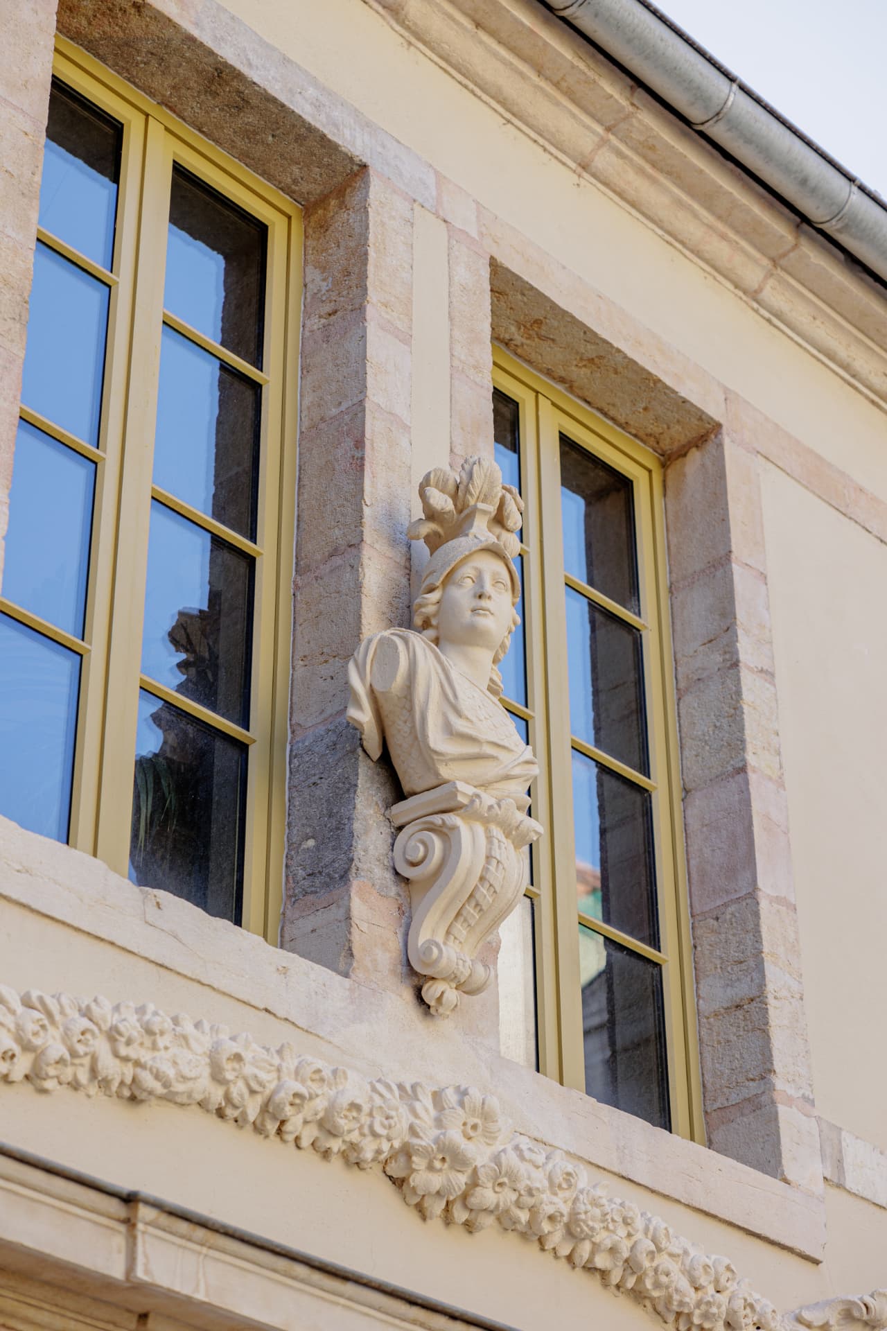 Détail patrimonial : buste sculpté en pierre et menuiseries de la Cour Bareuzai