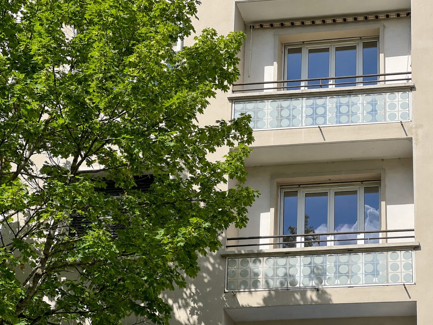 Façade en pierre de l'immeuble et balcons à garde-corps ouvragés, avenue Victor Hugo